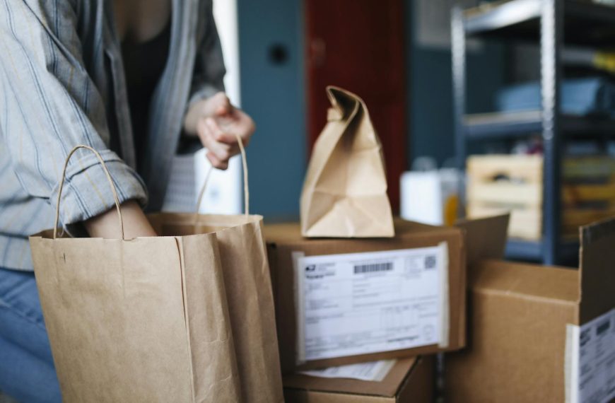 Woman sorting parcels and paper bags in a home setting, showcasing online shopping and delivery.