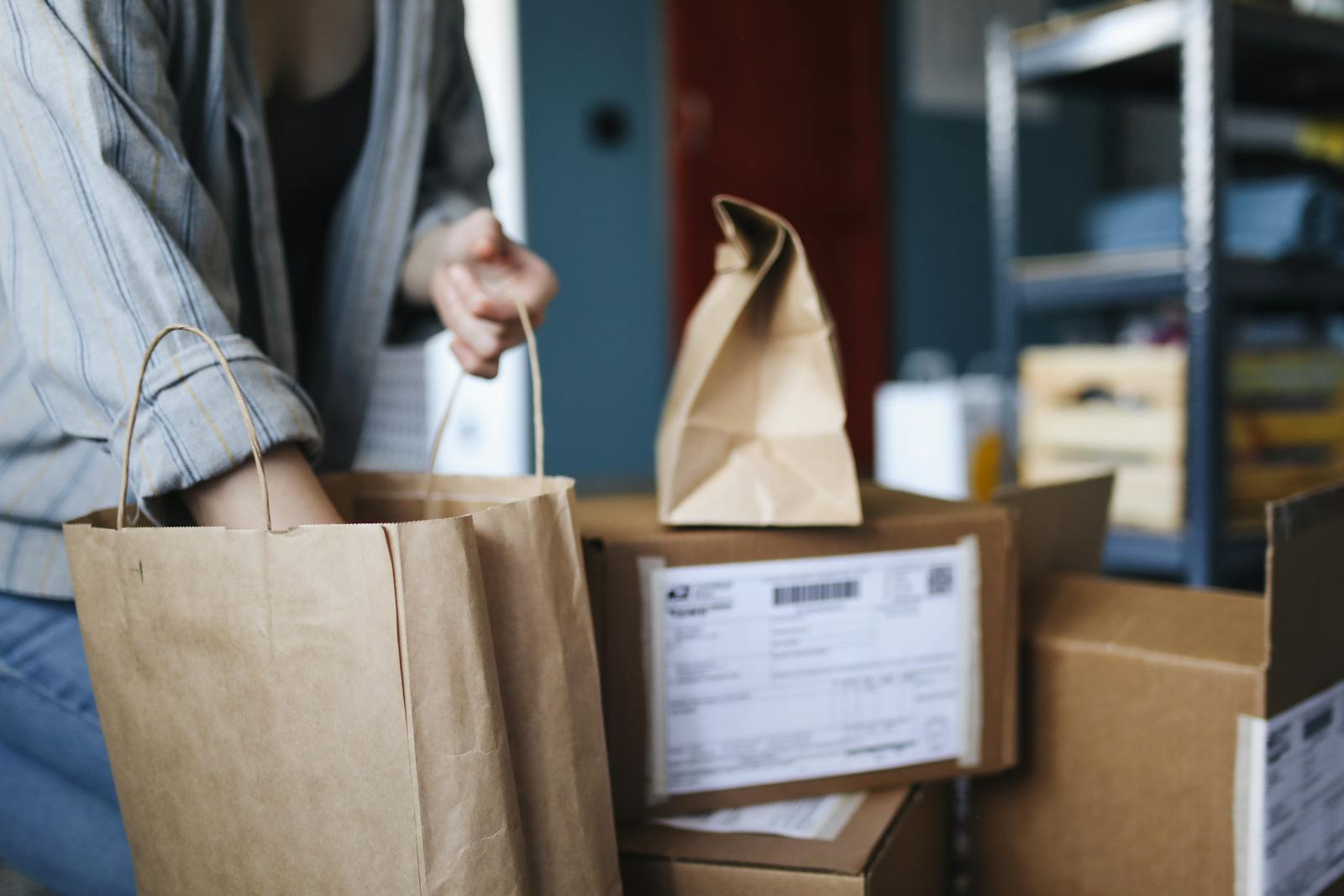 Woman sorting parcels and paper bags in a home setting, showcasing online shopping and delivery.