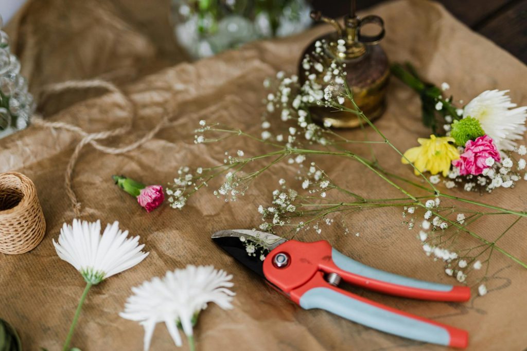 A detailed shot of floral tools, flowers, and materials in a workshop setting.