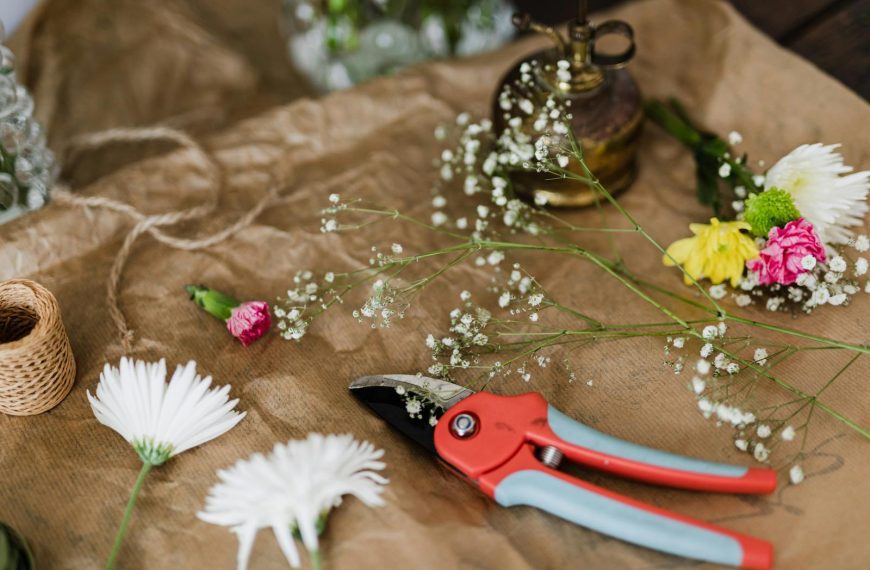 A detailed shot of floral tools, flowers, and materials in a workshop setting.