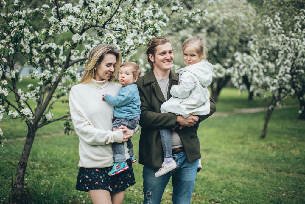 A family enjoying a spring day with blooming trees, capturing happiness and togetherness.