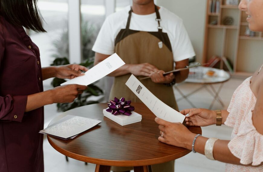 People reviewing a restaurant menu with a gift on a table indoors.