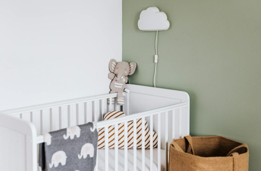 Modern baby room featuring a white crib, soft decor, and pastel accents.