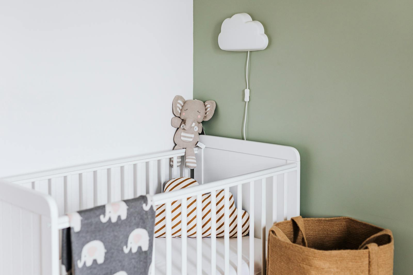 Modern baby room featuring a white crib, soft decor, and pastel accents.