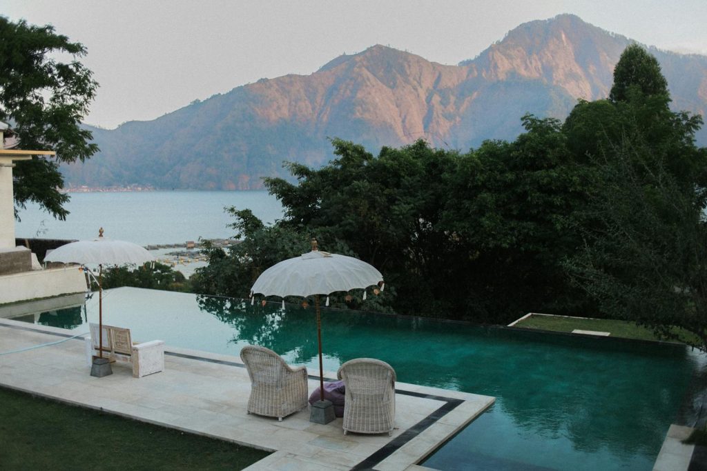 Relax by a serene infinity pool overlooking mountains and the ocean.