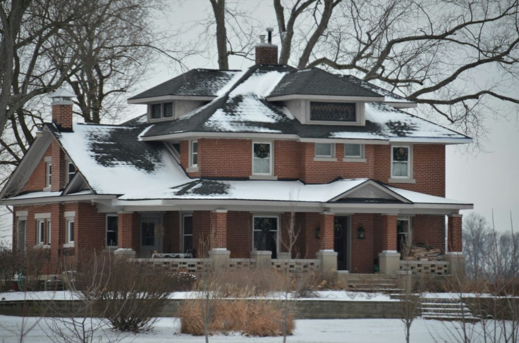 a large red brick house covered in snow