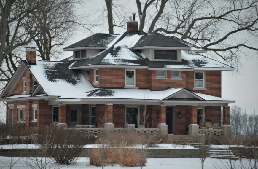 a large red brick house covered in snow