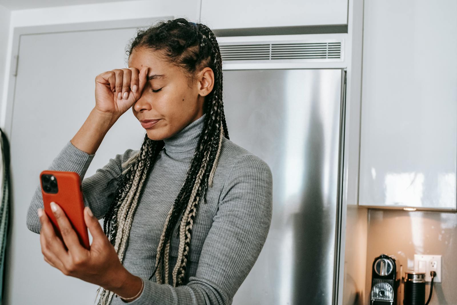 African American woman feeling stressed during a video call at home.