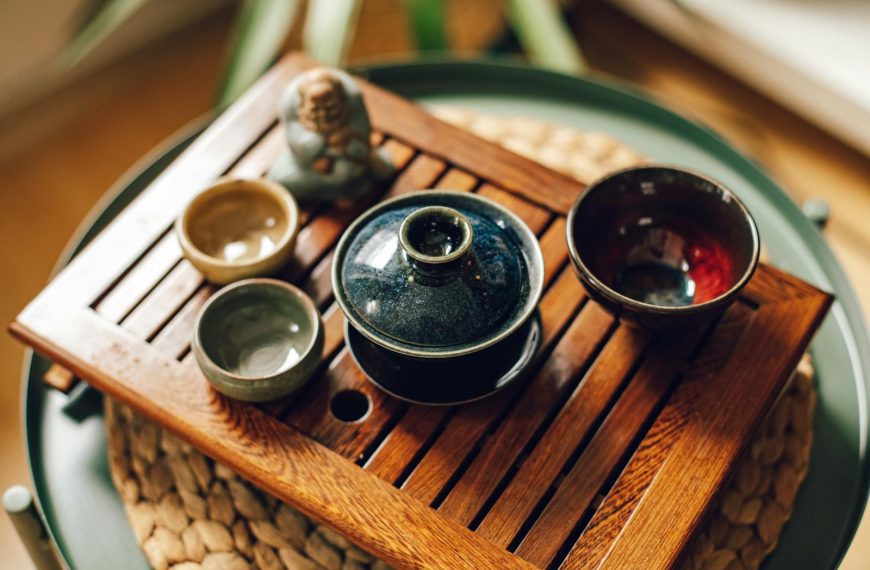Ceramic tea set on a wooden tray, showcasing Japanese design with earthy tones.