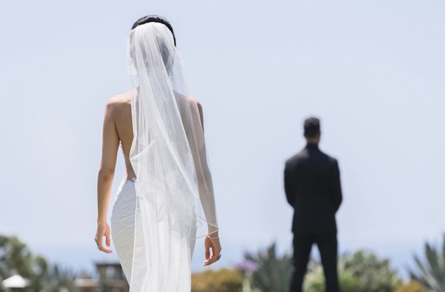 a woman in a wedding dress standing next to a man in a suit