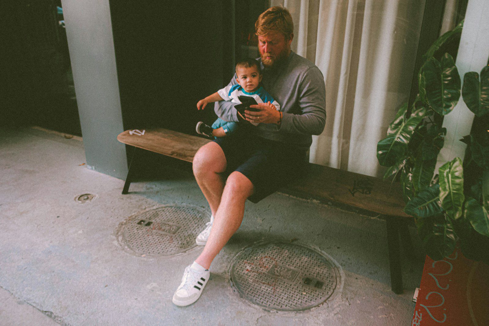 a man sitting on a bench holding a baby