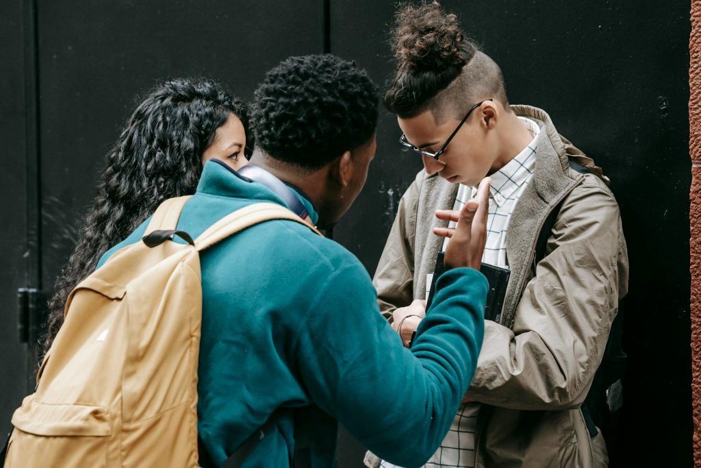 Group of diverse young adults passionately discussing on the street, displaying mixed emotions and active body language.