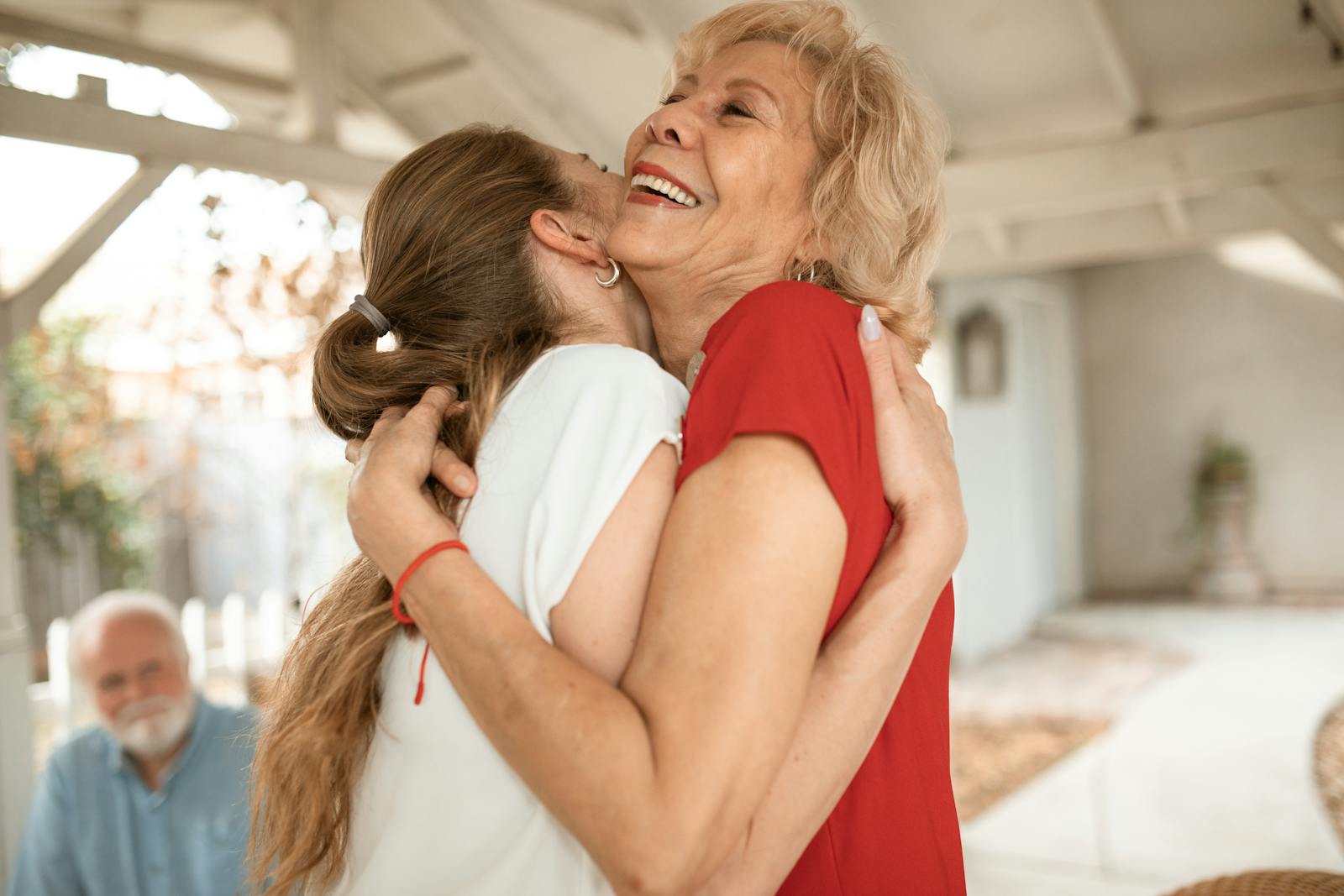 Heartwarming moment of two women sharing a joyful hug outdoors.