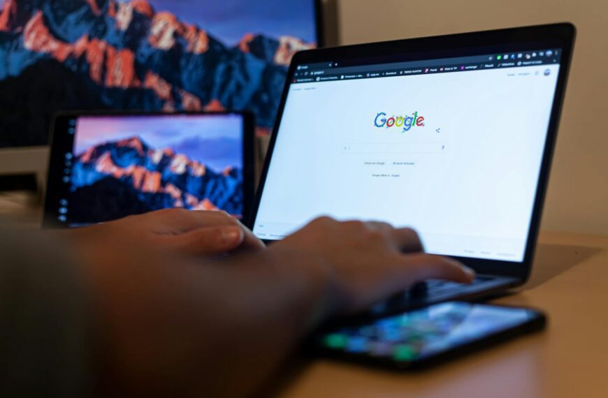 Hands typing on a laptop with Google on screen, in a remote work setup in Milan, Italy.