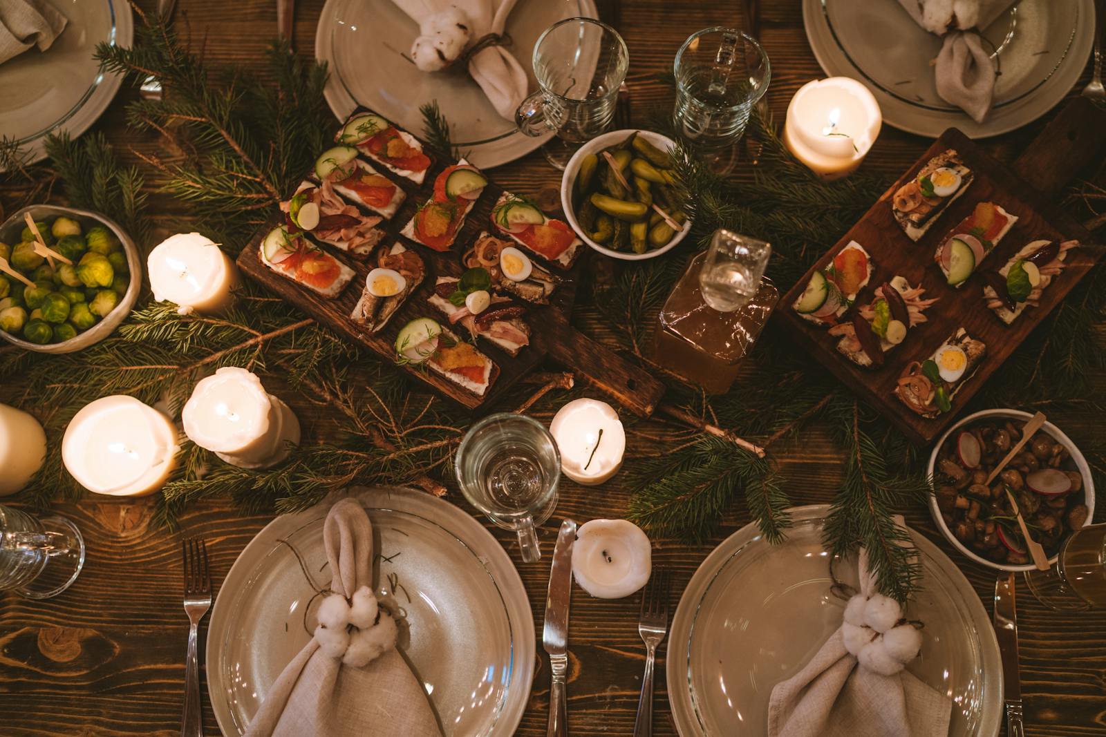Cozy holiday dinner table with festive decor, candles, and appetizers, perfect for family gatherings.