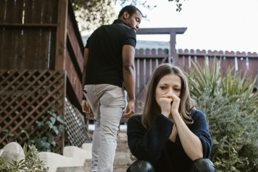 A couple facing emotional struggles captured in an outdoor setting.