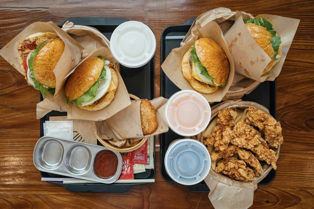 two trays of food with chicken sandwiches and dipping sauces