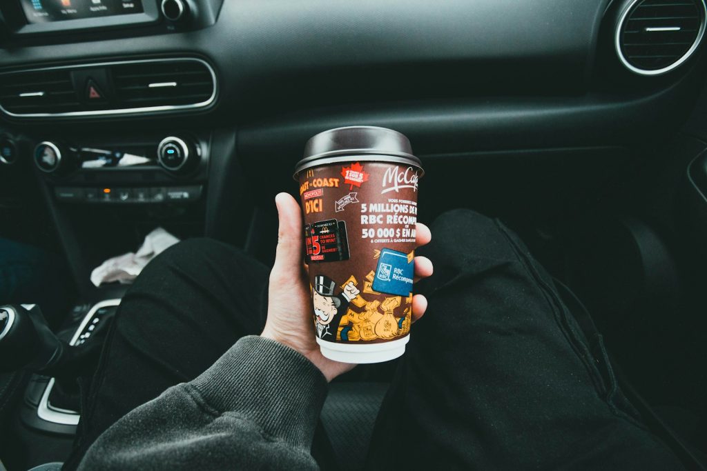 a person holding a cup of coffee in a car