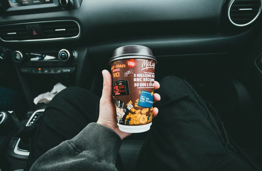 a person holding a cup of coffee in a car
