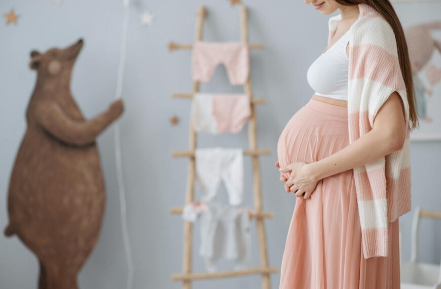Expectant mother caressing her belly in a cozy nursery room setting, symbolizing love and anticipation.