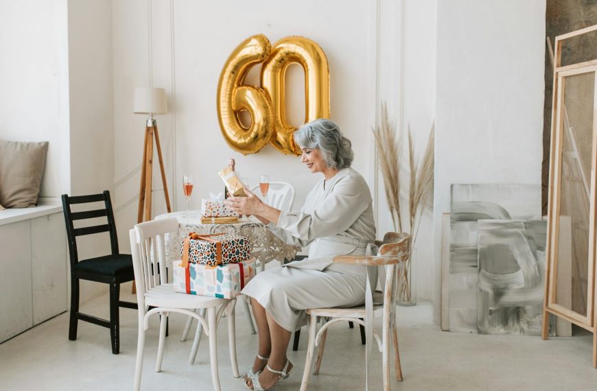 Senior woman celebrates her 60th birthday indoors with gifts and decor.