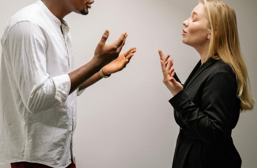 A couple engaged in a heated argument indoors, expressing strong emotions and gestures.