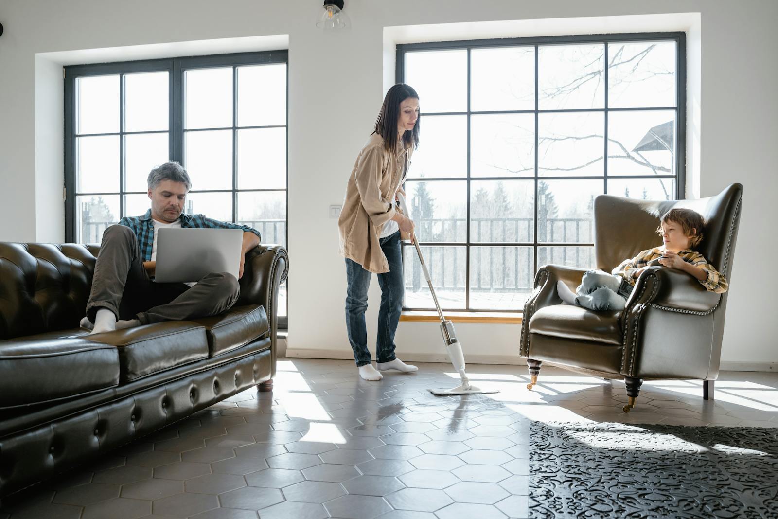 Family scene depicting vacuuming, working, and relaxing in cozy living room with natural light.