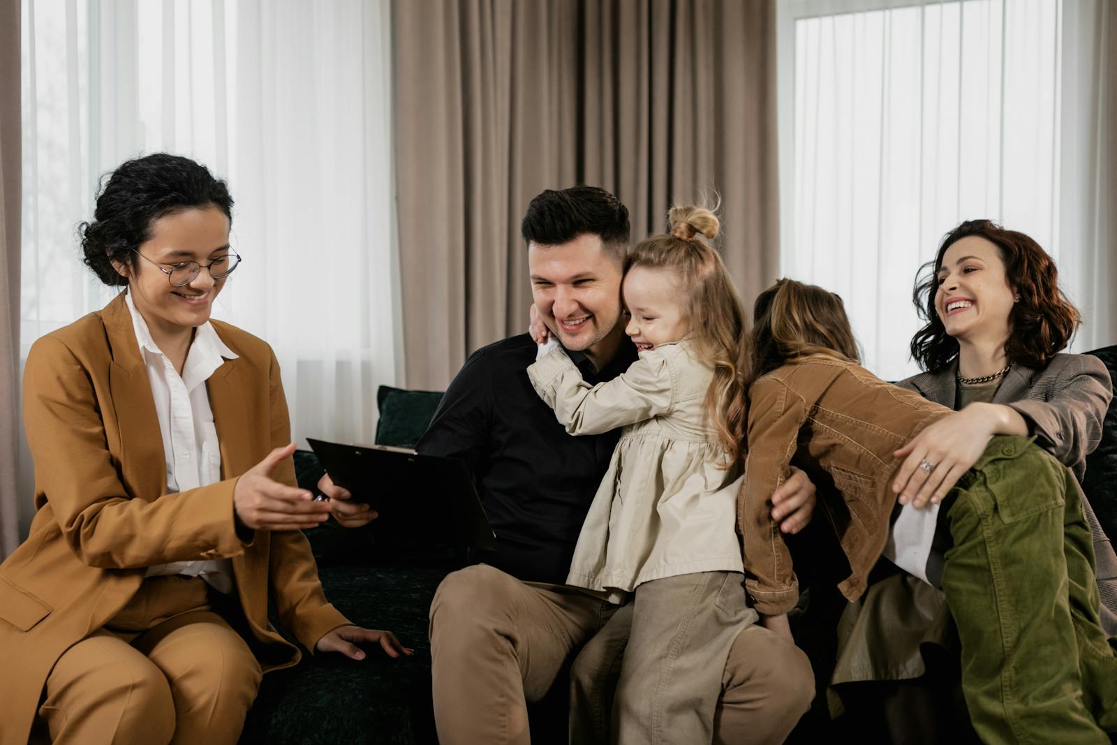 A joyful family bonding on a couch, sharing laughs and hugs indoors.