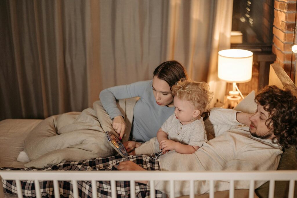 Father and mother reading to their child in bed during nighttime for a cozy bedtime story.