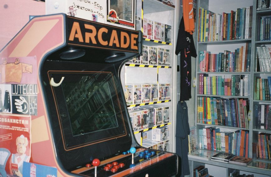 An arcade machine in front of a bookshelf