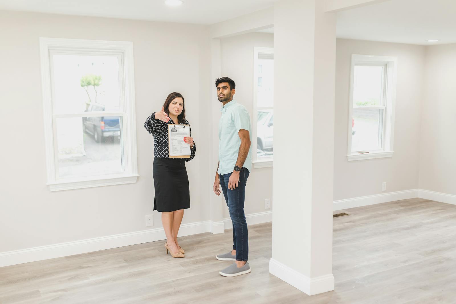 A real estate agent showing a potential buyer the interior of a new home.