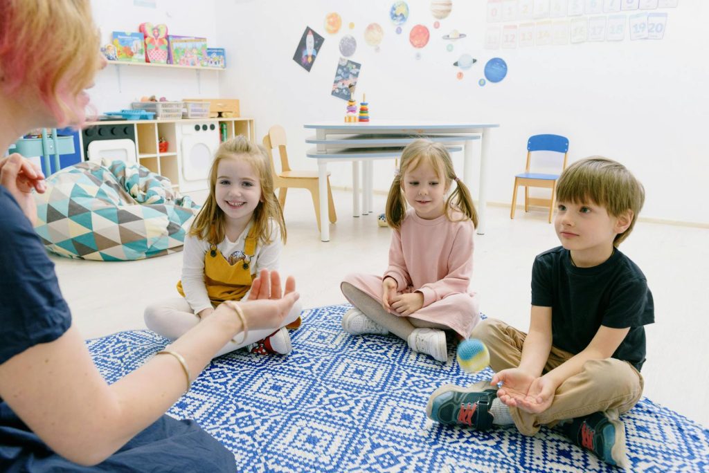 Happy children sitting indoors, enjoying fun learning activities in a kindergarten setting.