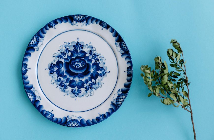 Artistic porcelain plate with intricate blue floral design on a blue background.
