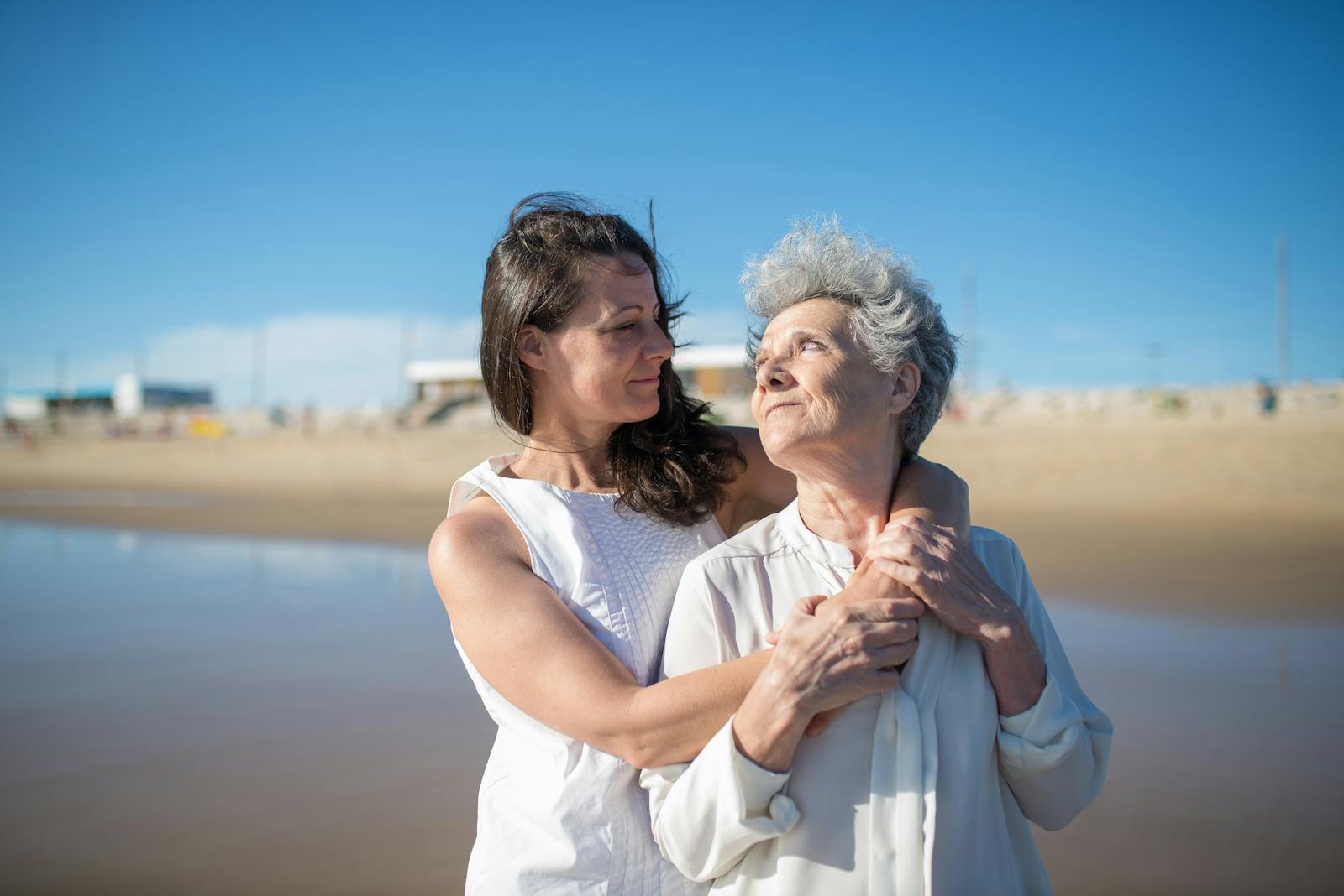 A loving embrace between a mother and daughter on a sunny beach in Portugal.