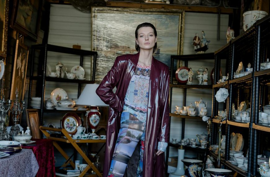 Stylish woman in a vintage outfit posing amidst antiques in an indoor flea market.