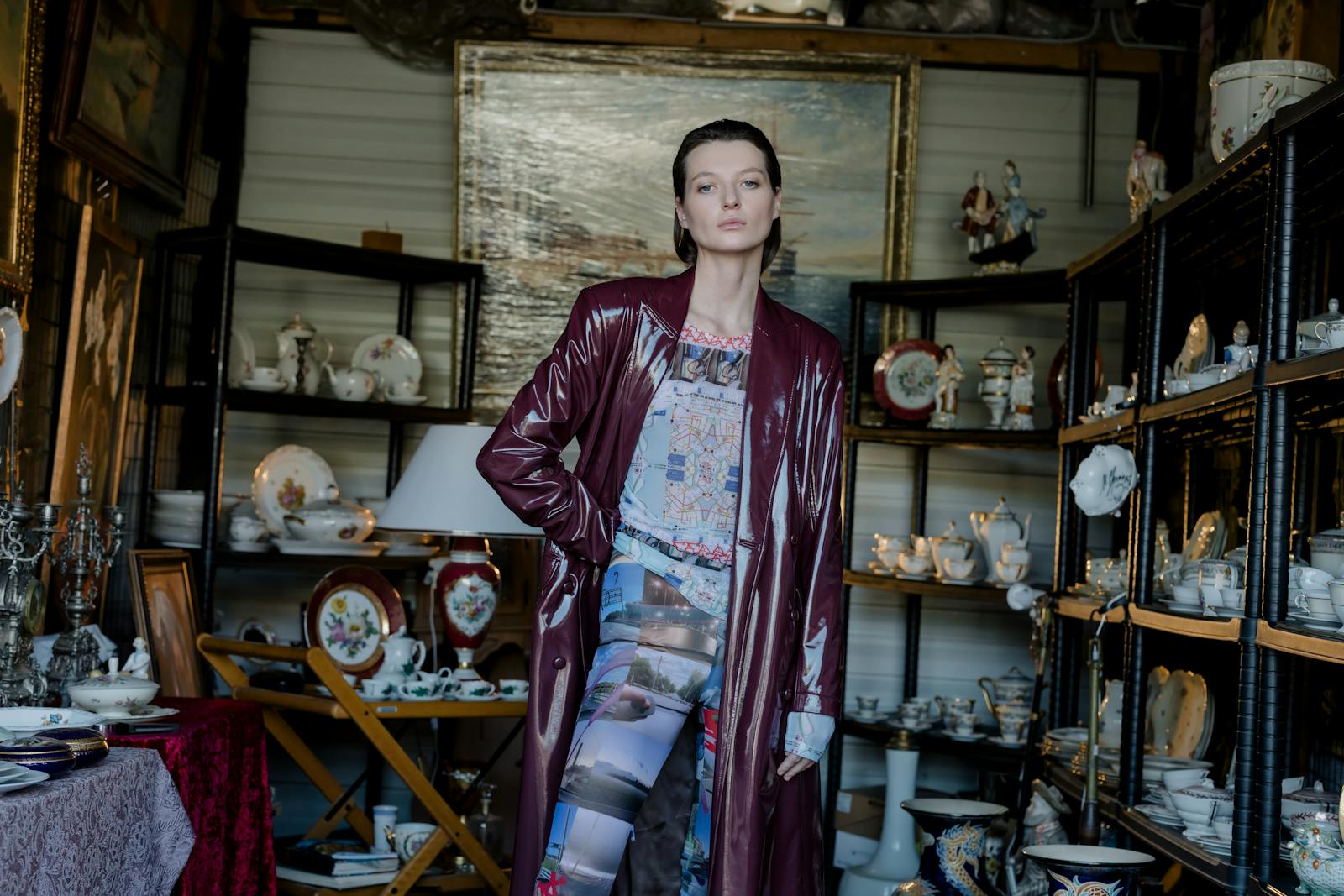 Stylish woman in a vintage outfit posing amidst antiques in an indoor flea market.