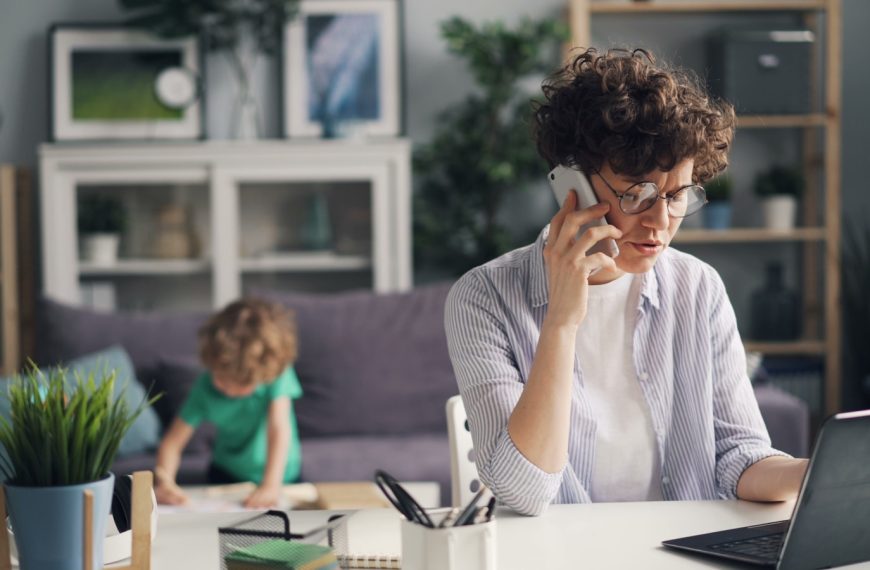 a woman sitting at a table talking on a cell phone
