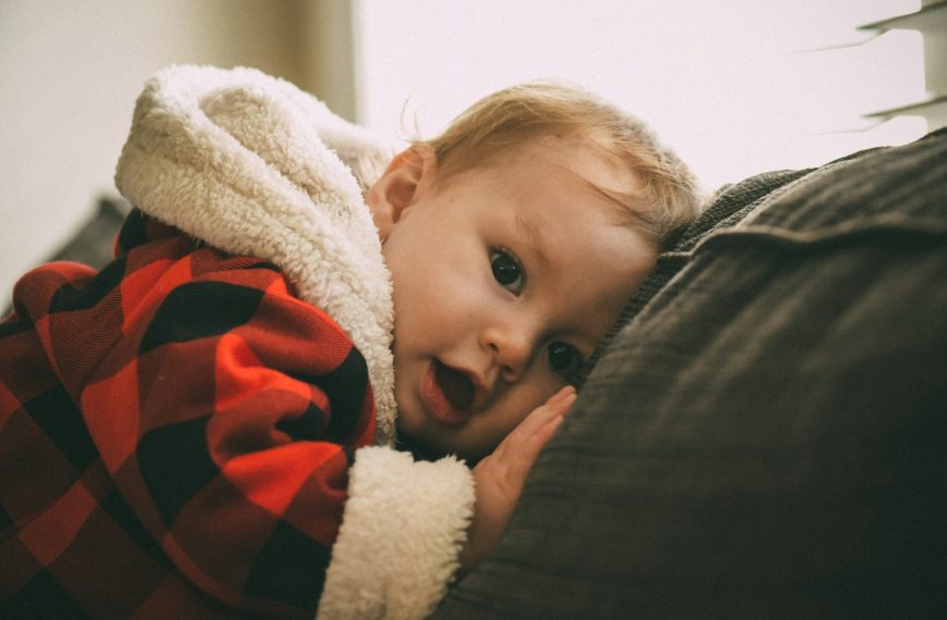 baby lying on black textile