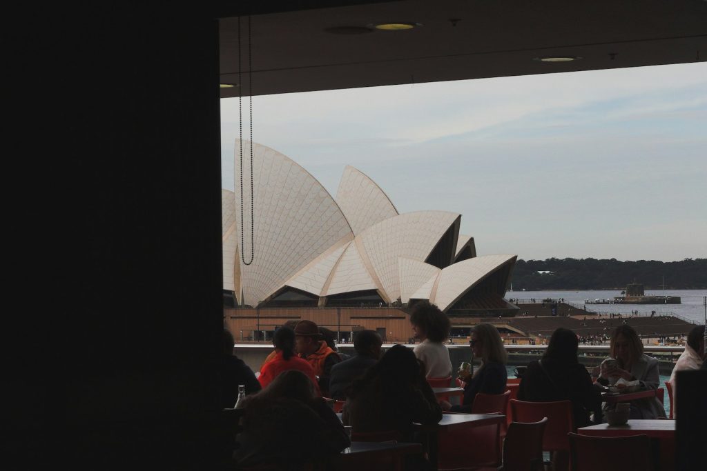 a group of people sitting at a table looking out at a large building
