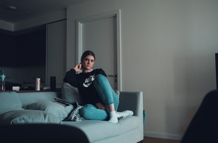 woman in black long sleeve shirt sitting on gray couch