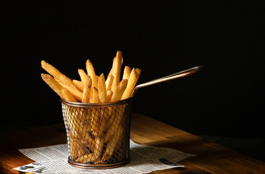 a basket of french fries sitting on top of a wooden table