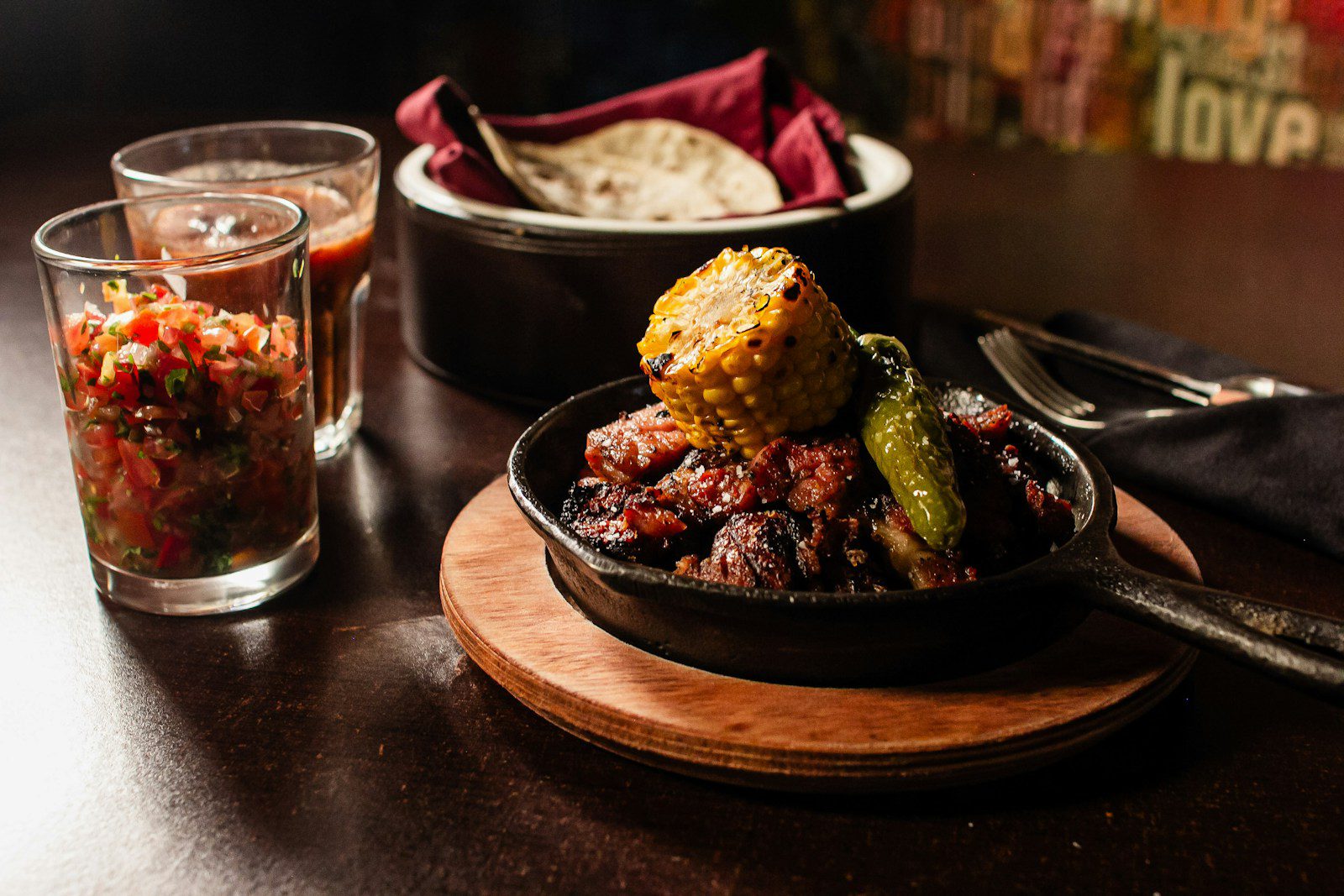 Hearty meat dish with corn and peppers served with salsa.