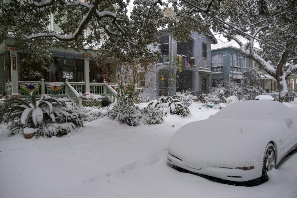 A car covered in snow parked in front of a house