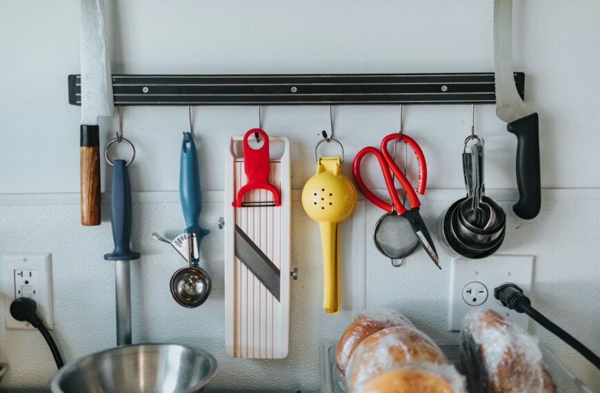 stainless steel cooking pot and red handled stainless steel spoon