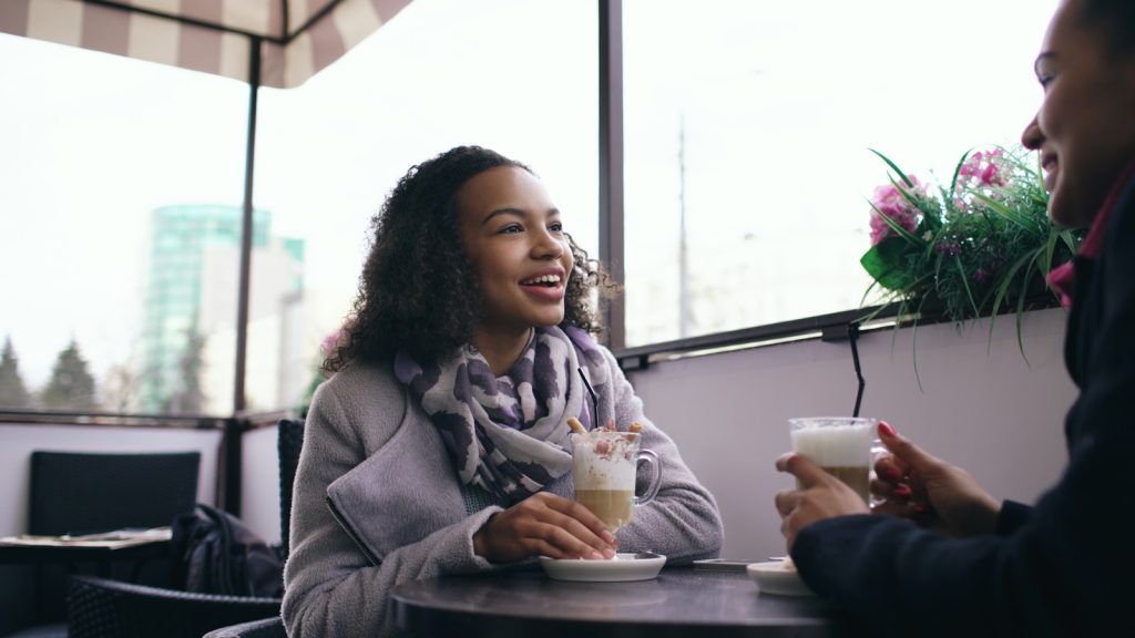 Two people enjoying coffee at an outdoor cafe.