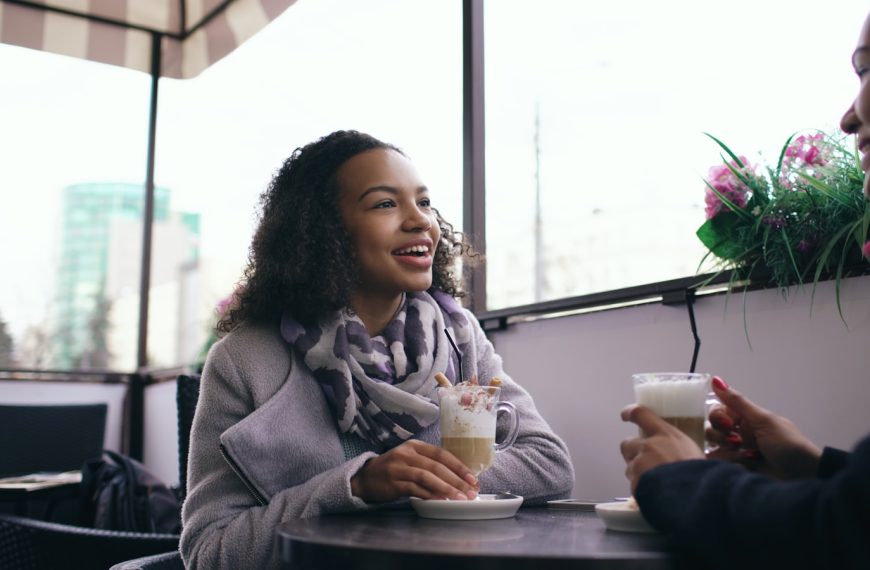 Two people enjoying coffee at an outdoor cafe.