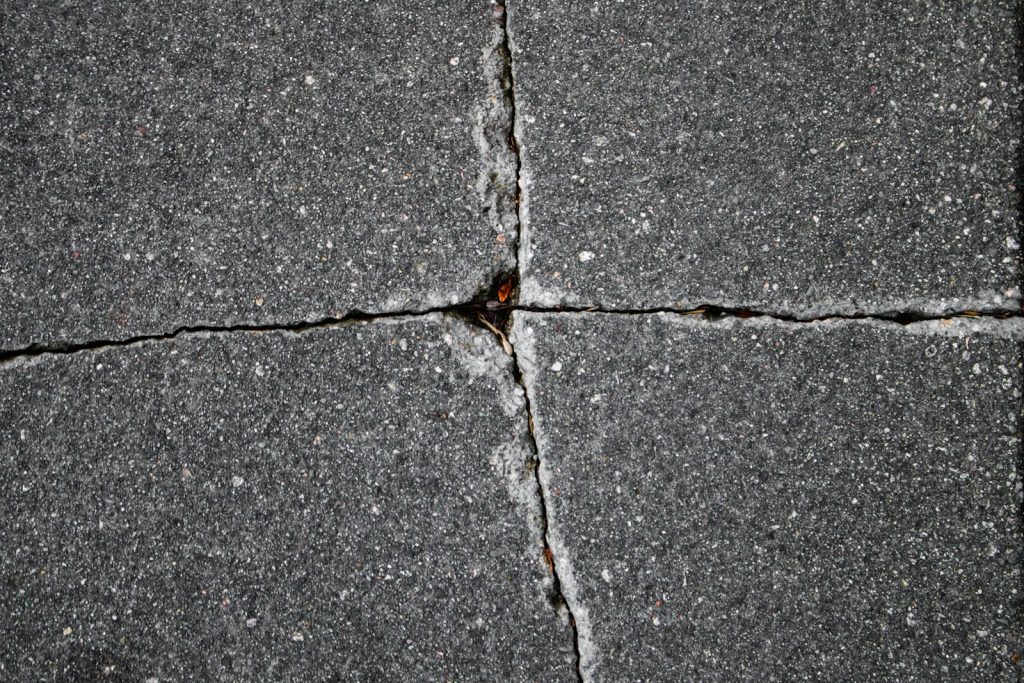 Cracked paving stones show a cross pattern.