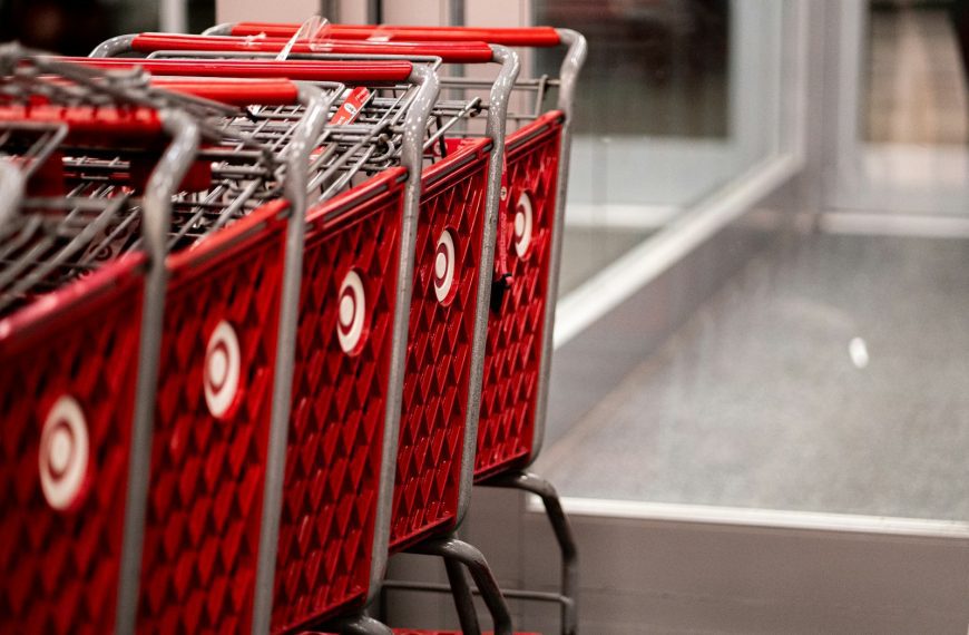 a row of red shopping carts sitting in front of a store