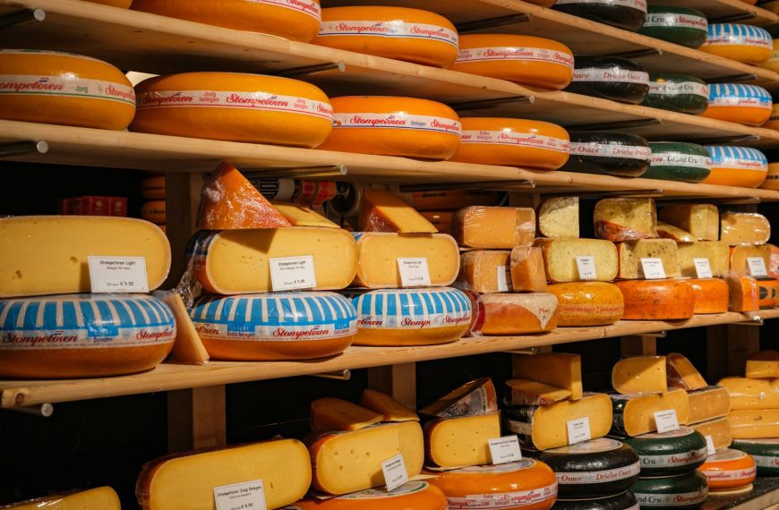 a shelf filled with lots of different kinds of cheese
