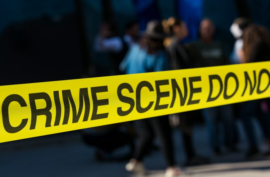 a group of people standing next to a yellow police line